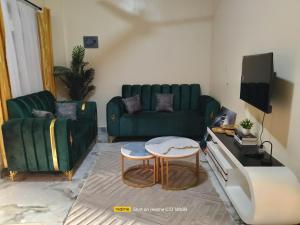 a living room with a green couch and a table at Luxury Homes in Mtwapa