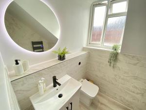 a white bathroom with a sink and a mirror at Luxury Scandi Inspired 1 Bed Apartment in Bournemouth