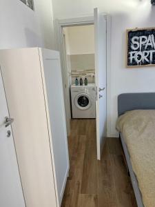 a bedroom with a door open to a washing machine at Antoni House in Bulzi