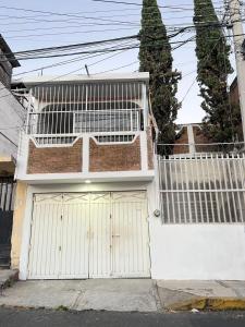 a house with two garage doors on a street at Casa Altamirano in Chilpancingo de los Bravos