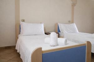 two beds in a room with towels on them at Hana's Apartment in Durrës