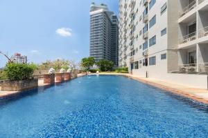 a swimming pool in the middle of a building at Breezy 1BR Near BTS Udomsuk in Amphoe Phra Khanong