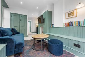 a living room with a blue couch and a table at Stunning Townhouse - 7 bedrooms - up to 18 Guests in Cardiff
