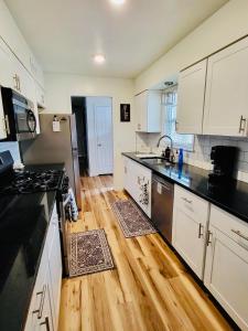 a kitchen with black and white appliances and wooden floors at The Willowdell Nook in Mulvane