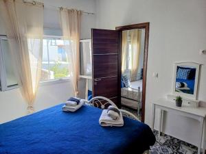 a bedroom with a blue bed and a window at Calliope#2 in Skala
