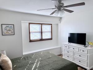 a living room with a ceiling fan and a flat screen tv at The Willowdell Nook in Mulvane