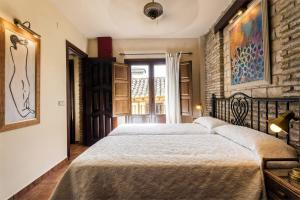 a bedroom with a large bed and a brick wall at Arte Vida Suites & Spa in Granada