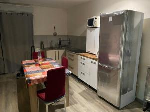 a kitchen with a table and a refrigerator at Maison de Campagne in Aussonne