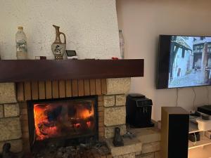 a living room with a fireplace with a tv at Maison de Campagne in Aussonne