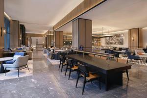 a restaurant with tables and chairs in a lobby at Sheraton Ningbo Yinzhou in Ningbo