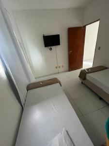 a room with a bed and a tv in it at Apartamento simples e Familiar conforto e sossego in João Pessoa