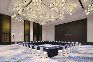 a conference room with a long table and white chairs at Sheraton Ningbo Yinzhou in Ningbo +56 photos