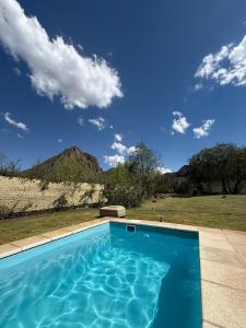 a blue swimming pool with a mountain in the background at Cabaña La Verdicchio Privacidad y exclusividad Tu lugar de descanso in Valle Grande