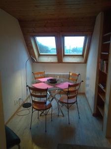 a dining room with a pink table and chairs at Gästezimmer Stadtpark in Biel