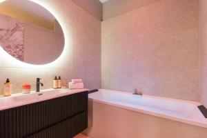 a bathroom with a tub and a sink at Host Inn Velvy Suite in Lyon