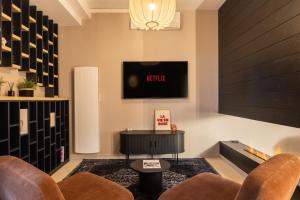 a living room with two chairs and a tv at Host Inn Velvy Suite in Lyon +9 photos