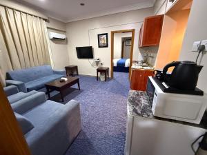 a living room with a couch and a tv in a hotel room at سحابة صيف للشقق المخدومه 1 - حي النزهه - in Abha