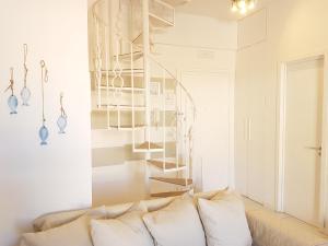 salon z kanapą i spiralnymi schodami w obiekcie La Casa Bianca w mieście Ceriale
