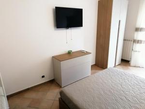 a bedroom with a bed and a tv on a wall at Villetta da Amare in Imperia