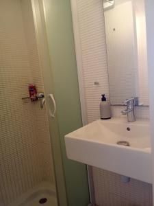 a bathroom with a sink and a shower with a mirror at Maison cosy Santa Barbara in Le Barcarès +13 photos