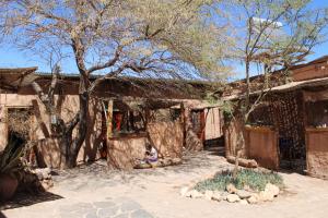 a person sitting in front of a building at Hostal Sonchek in San Pedro de Atacama