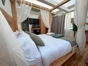 a bedroom with a canopy bed with white sheets and pillows at Casa Luna Beach-Front Suite in Dahab