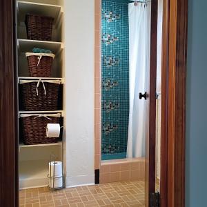 a bathroom with a shower curtain and a toilet at Cliffside Cottage in Mansfield +30 photos