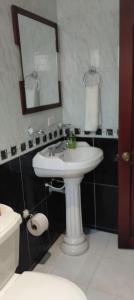 a bathroom with a white sink and a mirror at La Pradera in Pereira