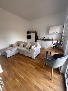 a living room with a white couch and a table at Holiday by Chelly in Zeitz +5 photos