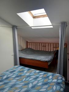 a bedroom with a bed and a skylight at Maison cosy Santa Barbara in Le Barcarès
