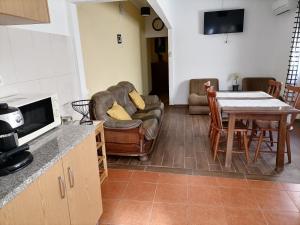 a kitchen and living room with a couch and a table at Casa das 4 estações in Castelo Branco