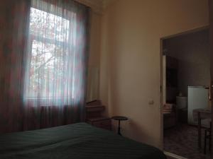 ピャチゴルスクにあるApartment ul. Karla Marksa 21のベッドルーム1室(ベッド1台付)、窓(カーテン付)