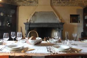 a table with plates and wine glasses and a fireplace at Ca' d'Alfieri in Bardi
