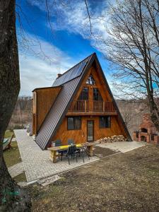 a large wooden cabin with a picnic table and chairs at Dream Cottage in Paltin