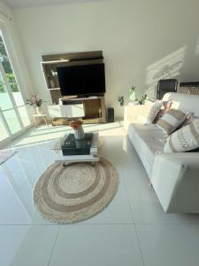 a living room with a couch and a tv at Casa WHITE in Melgar