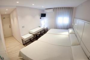 Postel nebo postele na pokoji v ubytování Hostal Loimar