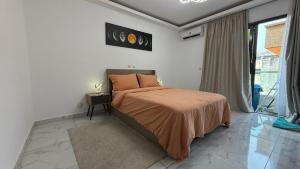 a bedroom with a bed with an orange bedspread at Eucalyptus in Abidjan