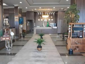 a lobby with potted plants on the floor of a store at الاطلاله للشقق المخدومة in Khamis Mushayt