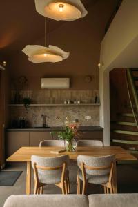a dining room with a wooden table and chairs at Gastenverblijf Buitenhoudt in Vinkel