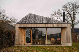 a small wooden house with a table and chairs at Gastenverblijf Buitenhoudt in Vinkel