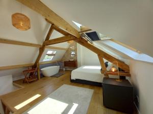 a attic bedroom with a bed and a bath tub at CountrySide Heaven in Neuilly-sur-Eure +19 photos