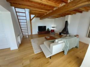 a living room with a white couch and a television at CountrySide Heaven in Neuilly-sur-Eure