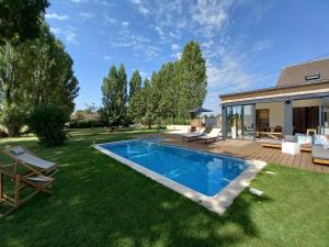 a backyard with a swimming pool and a house at CountrySide Heaven in Neuilly-sur-Eure