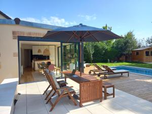 a patio with a table and an umbrella at CountrySide Heaven in Neuilly-sur-Eure