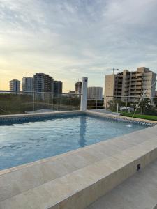 a large swimming pool with a city in the background at Hotel Bello Horizonte in Santa Marta