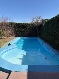 a large blue swimming pool next to a hedge at Moon of Salta in Salta