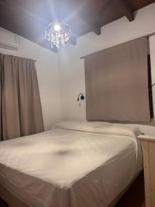 a bedroom with a white bed and a chandelier at Moon of Salta in Salta