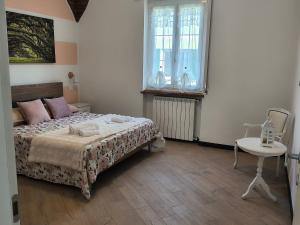 a bedroom with a bed and a table and window at L'Eden in Casarza Ligure