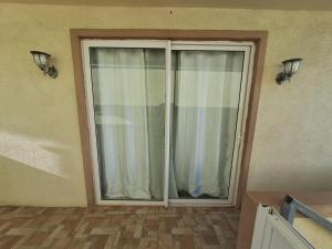 a sliding glass door with a window in a room at Authentic South in Mahébourg