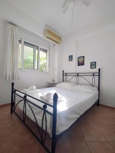 a bedroom with a large bed with white sheets and a window at O&A Kallithea in Kallithea Halkidikis